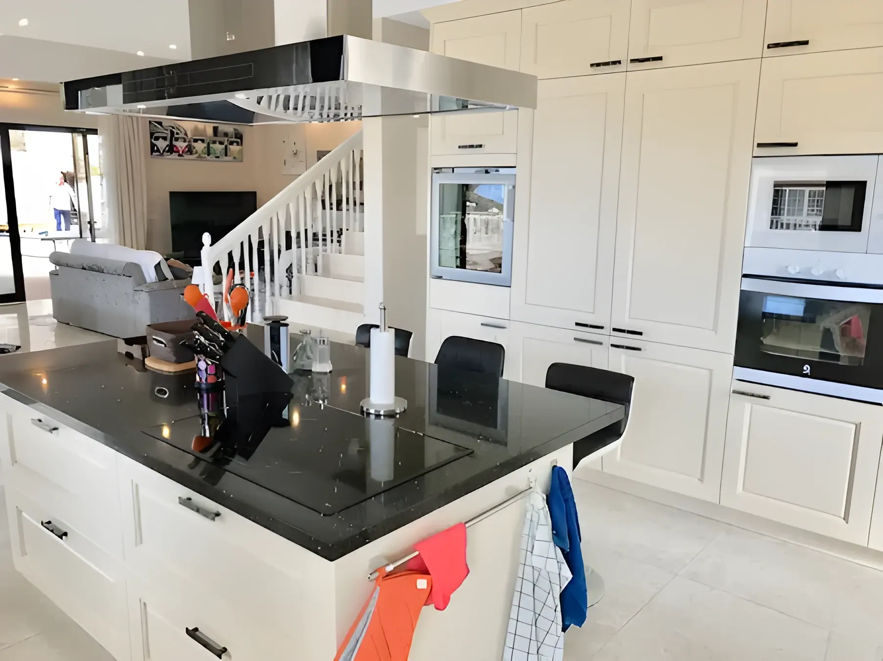 Cocina con isla central, encimera de granito y horno doble