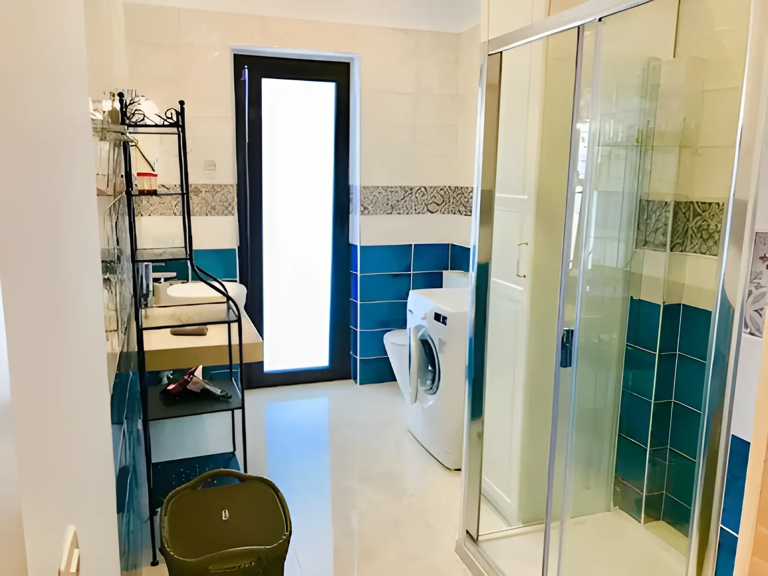 Cuarto de lavado con lavadora y ducha