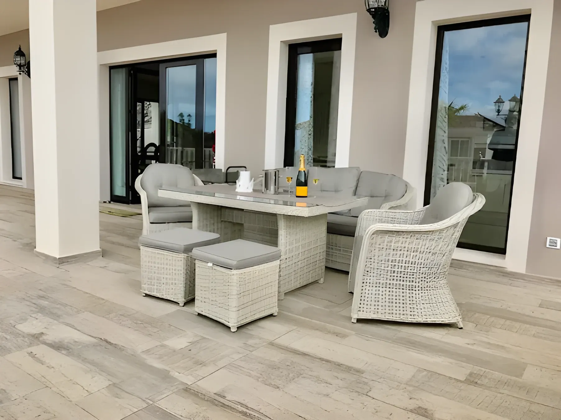 Terraza lounge con sofás de ratán frente a la fachada