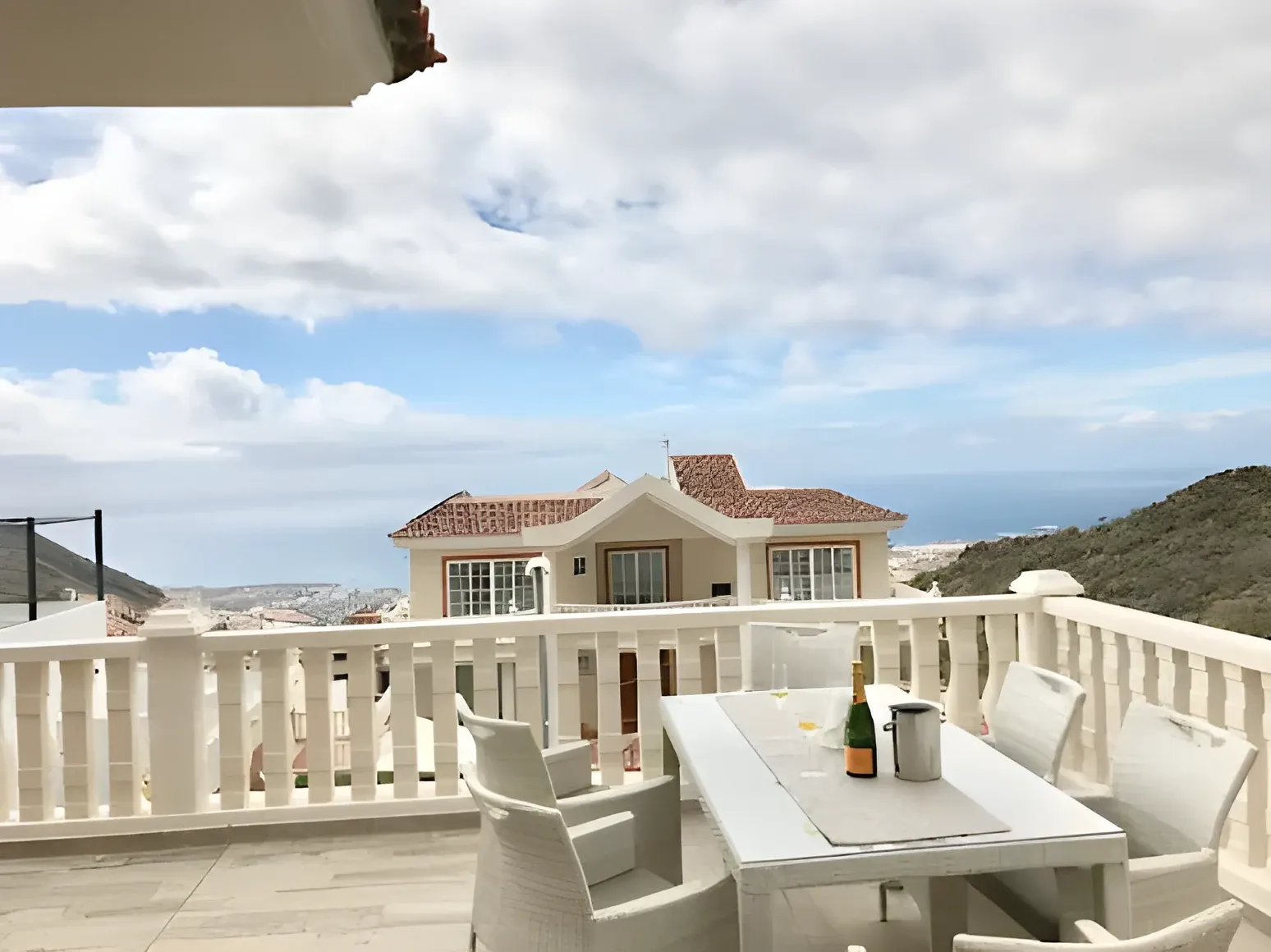 Terraza superior con mesa preparada y la villa al fondo