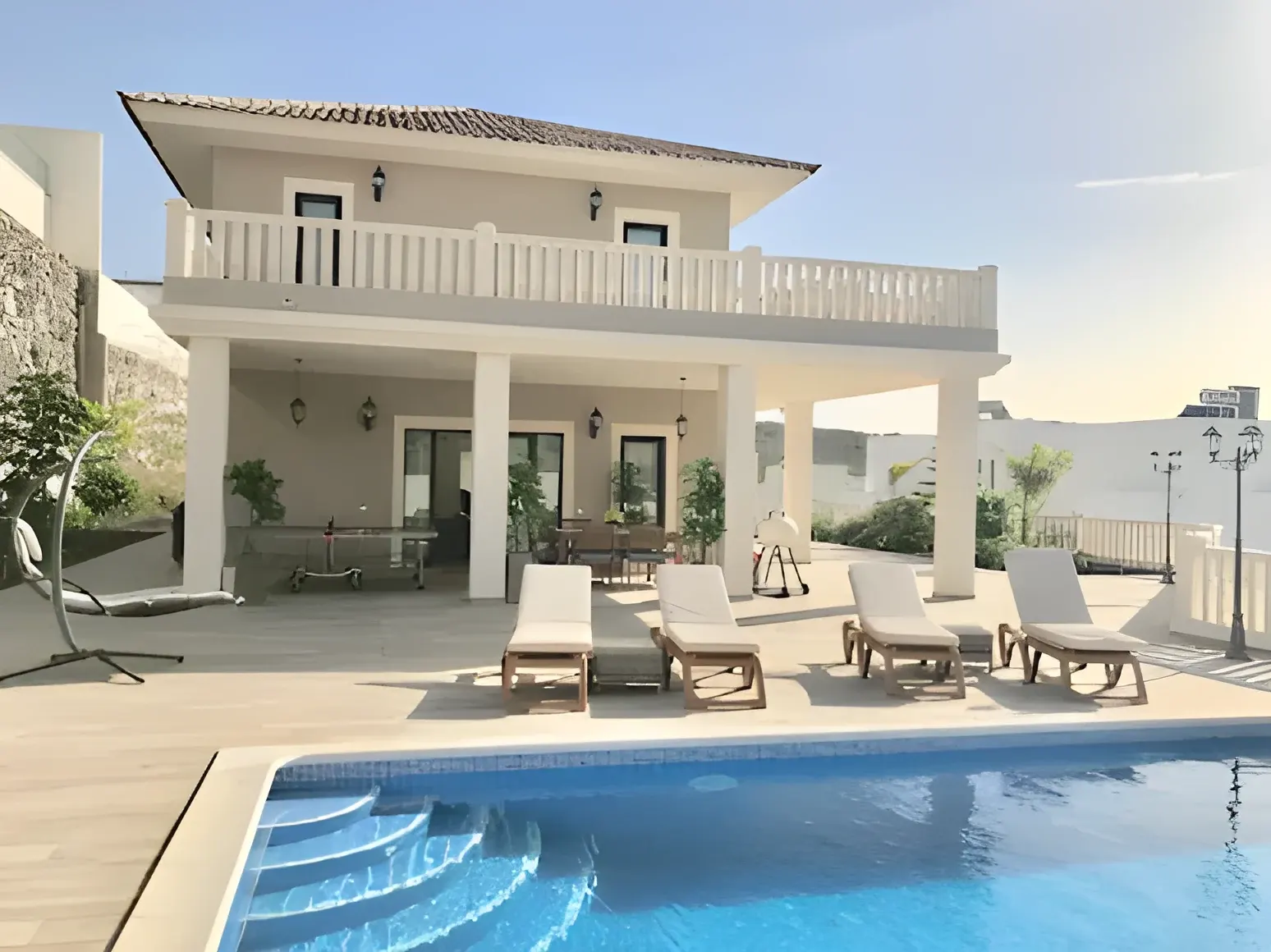 Fachada de Villa Jensen vista desde la piscina, con tumbonas al sol